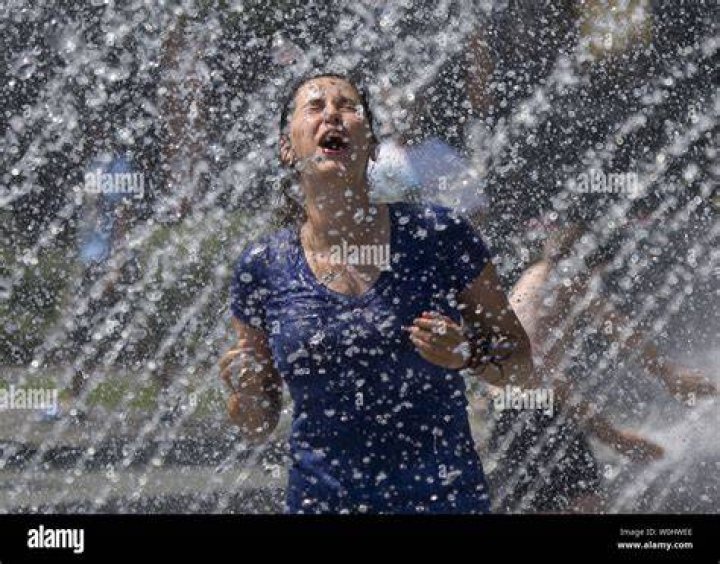 A woman cools off in water fountains in a park as hot summer temperatures hit Paris, France, June 22, 2017. Photo by REUTERS/Jean-Paul Pelissier