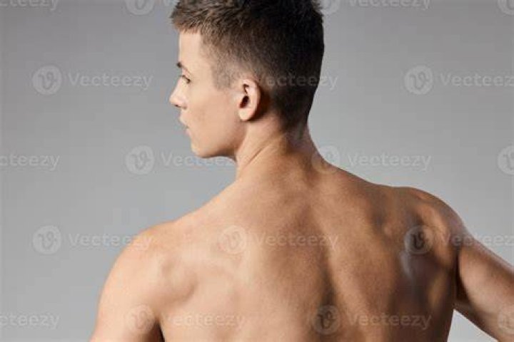 Cropped back view of beautiful young European woman with skin condition that causes loss of melanin posing indoors. Slender slim female model in black tank top suffering from vitiligo disorder cropped back view of beautiful young european woman with skin condition that causes loss of melanin posing indoors slender slim female model in black tank top suffering from vitiligo disorder