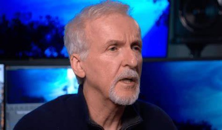 James Cameron speaking with a microphone in his hand at the 'Avatar: The Way of Water' press conference.