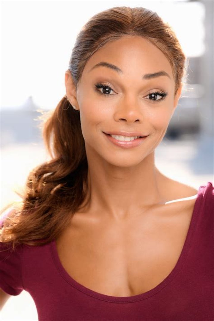 Jasmine Davis as her 'The Chi' character Imani wearing blonde hair and a sweater with a startled look on her face