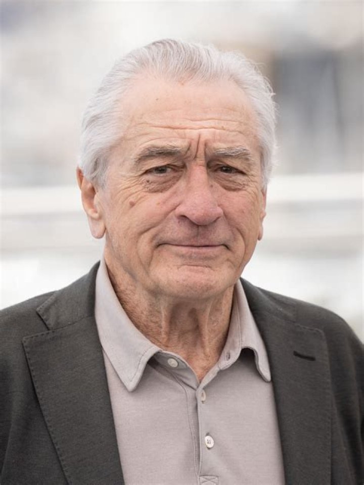 Robert De Niro posing in a suit at the Oscars.