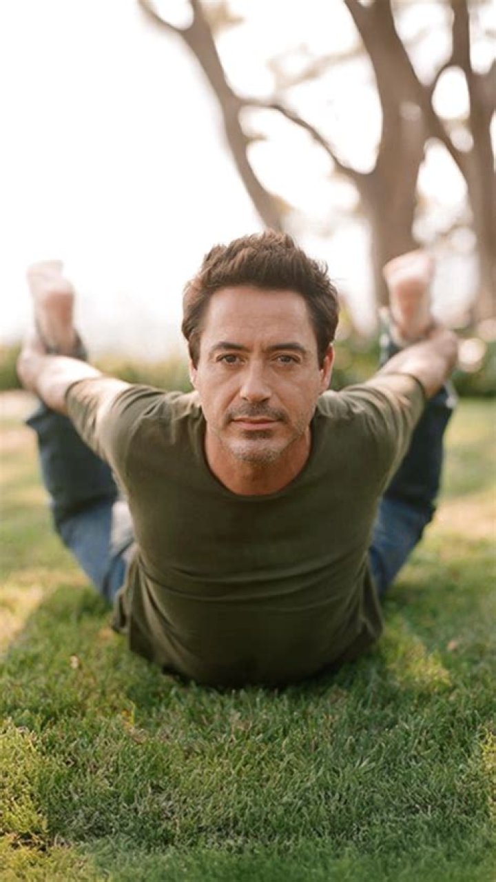Robert Downey Jr. posing in a tan suit at the Oscars.